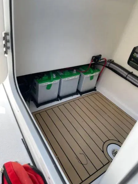 Slide: The Image of 2021 Sportsman MASTERS 247 BAY boat battery compartment with three batteries and wiring. - 6