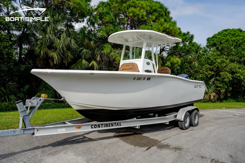 Slide: The Image of 2024 Sea Pro 239 Deep V CC boat on trailer, parked outdoors. - 2