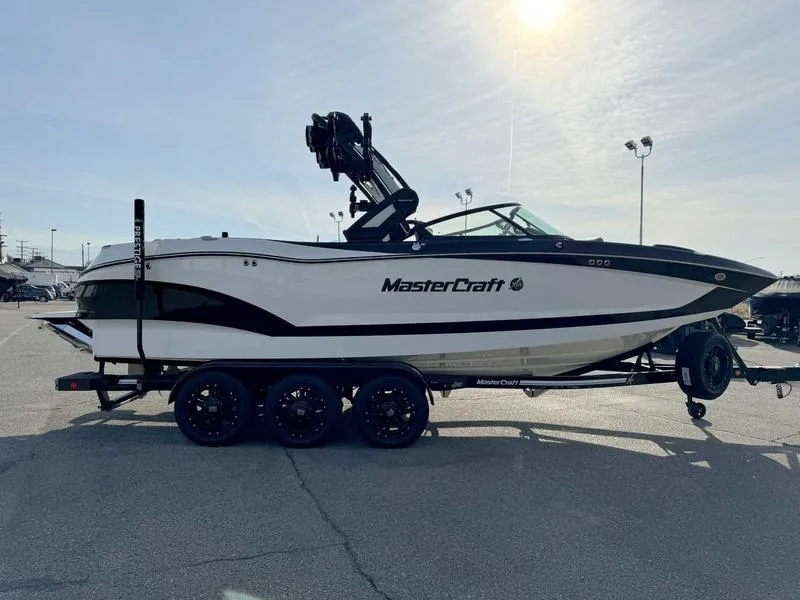Slide: The Image of 2024 MasterCraft X24 boat on trailer in sunny parking lot. - 3