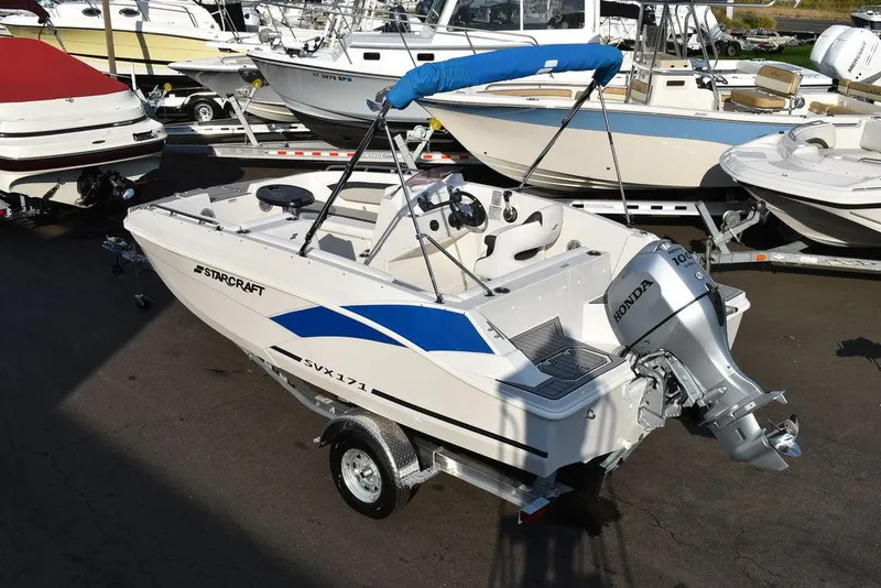 Slide: The Image of 2022 Starcraft SVX 171 boat with Honda outboard motor, parked on a trailer. - 6