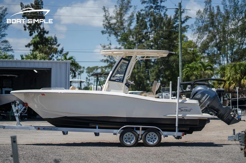 Slide: The Image of 2023 Scout 215 XSF boat on trailer, parked outdoors, side view. - 3