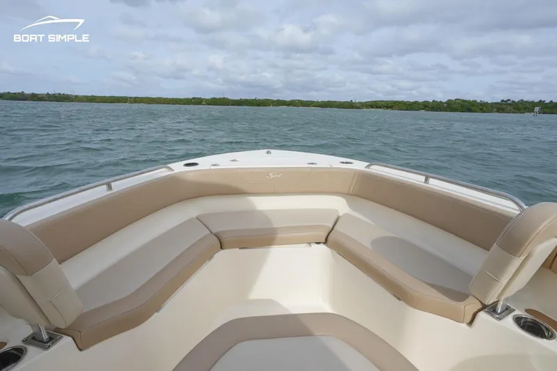Slide: The Image of 2023 Scout 215 XSF boat interior with cushioned seating on open water. - 7