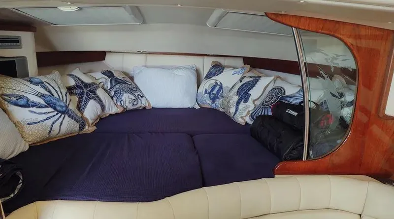 Slide: The Image of 2006 Grady-White Express 360 cabin with nautical-themed pillows and cozy bedding. - 14