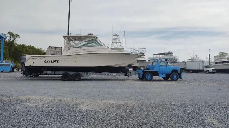 Slide: The Image of 2006 Grady-White Express 360 boat on trailer, towed by blue truck in marina. - 20