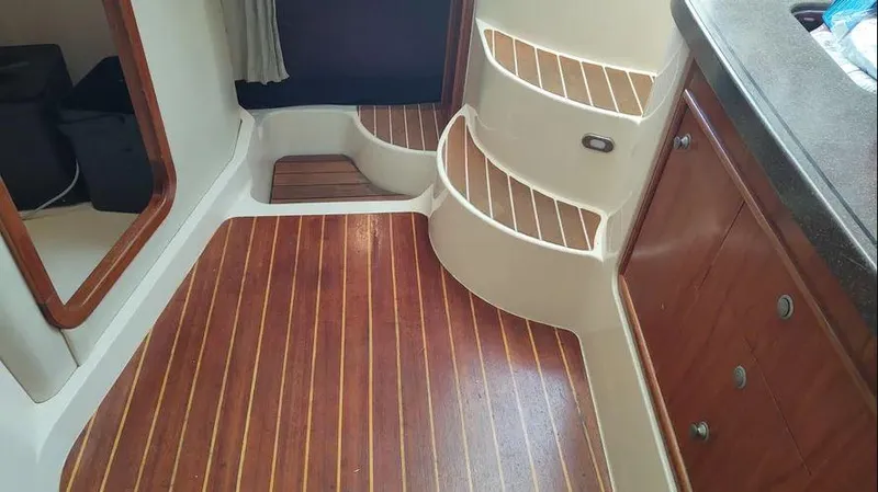 Slide: The Image of 2006 Grady-White Express 360 interior with wooden flooring and curved steps. - 9