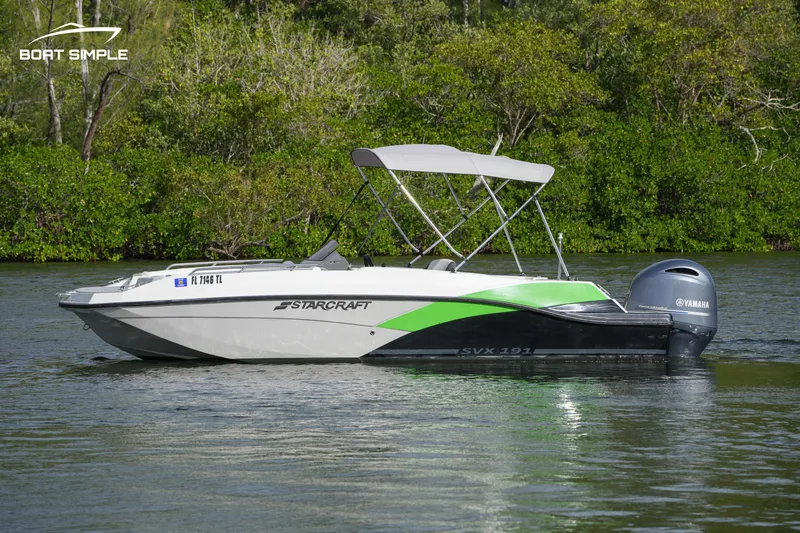 Slide: The Image of 2023 Starcraft SVX 191 OB boat on a calm lake with lush greenery. - 3