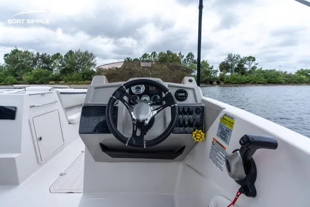 Slide: The Image of 2023 Starcraft SVX 231 OB DH boat cockpit with steering wheel and controls. - 8