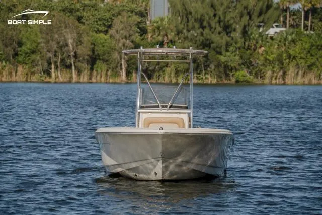 Slide: The Image of 2022 Scout 195 Sportfish boat on calm water, surrounded by lush greenery. - 1