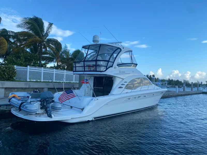Slide: The Image of 2007 Sea Ray 52 Sedan Bridge yacht docked by palm trees and calm water. - 11