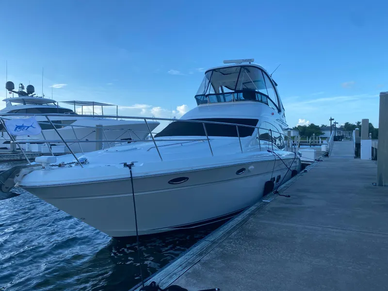 Slide: The Image of 2007 Sea Ray 52 Sedan Bridge yacht docked at marina under clear blue sky. - 13