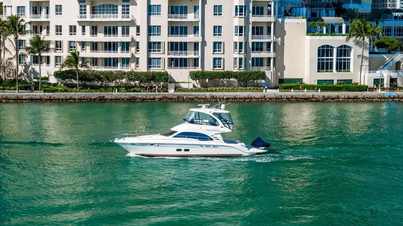 Slide: The Image of 2007 Sea Ray 52 Sedan Bridge yacht cruising near waterfront buildings. - 50