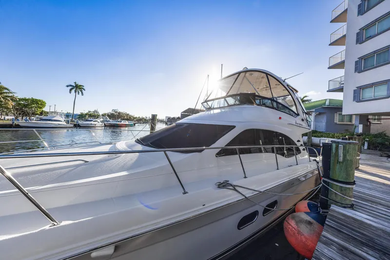 Slide: The Image of 2007 Sea Ray 52 Sedan Bridge yacht docked at marina under clear blue sky. - 6