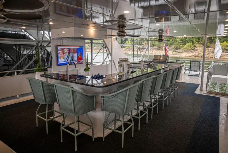 Slide: The Image of Luxurious 2020 Thoroughbred houseboat interior with modern kitchen, bar seating, and outdoor views. - 4