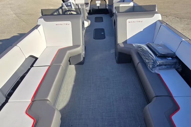 Slide: The Image of 2025 Manitou 240 Cruise pontoon boat interior with gray seating and red accents. - 6