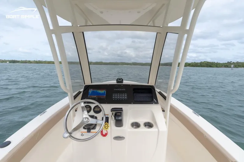 Slide: The Image of 2023 Scout 215 XSF boat dashboard with steering wheel on open water. - 6