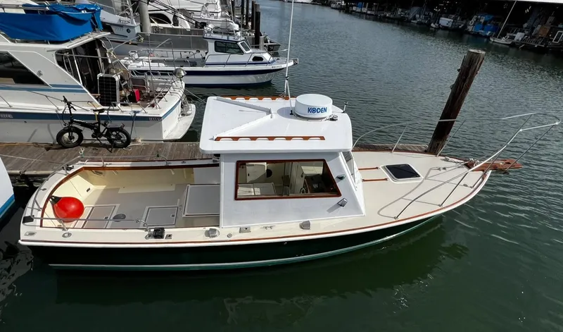 Slide: The Image of 1974 Dyer 29' Sport Fisher boat on calm water, surrounded by houses and other boats. - 2