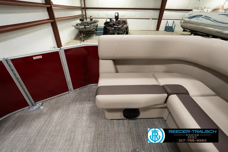 Slide: The Image of 2025 Bennington 21 SLSE pontoon boat interior with beige seating and red paneling. - 14