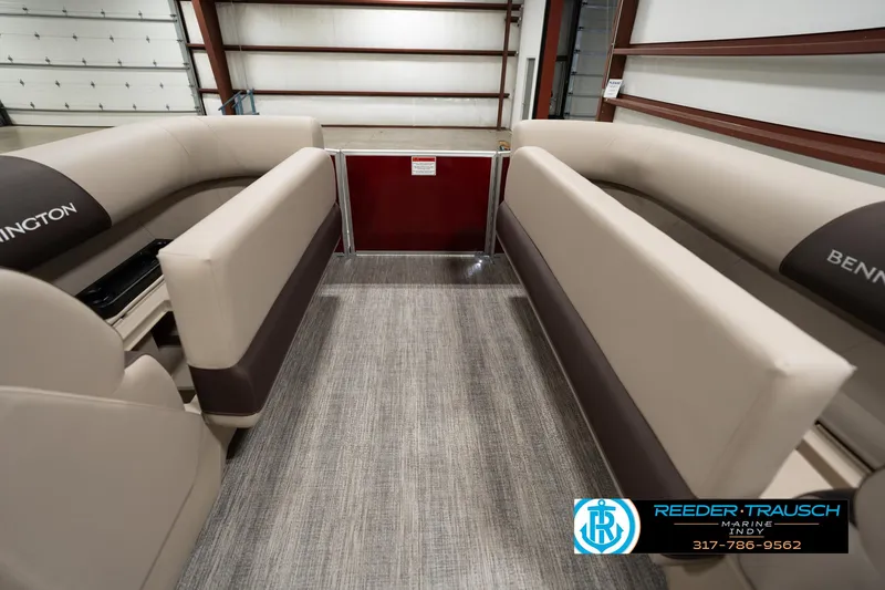 Slide: The Image of 2025 Bennington 21 SLSE pontoon boat interior with beige seating in a showroom. - 18