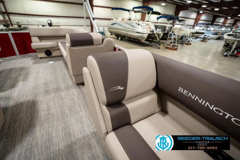 Slide: The Image of 2025 Bennington 21 SLSE pontoon boat interior with beige and brown seating in showroom. - 19