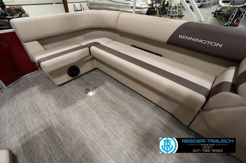 Slide: The Image of 2025 Bennington 21 SLSE pontoon boat interior with beige seating and carpet flooring. - 21