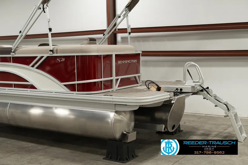 Slide: The Image of 2025 Bennington 21 SLSE pontoon boat in a showroom, featuring red and silver design. - 41