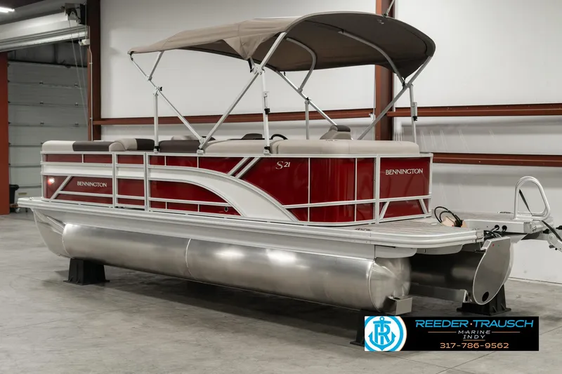 Slide: The Image of 2025 Bennington 21 SLSE pontoon boat with red and white design in a showroom. - 5