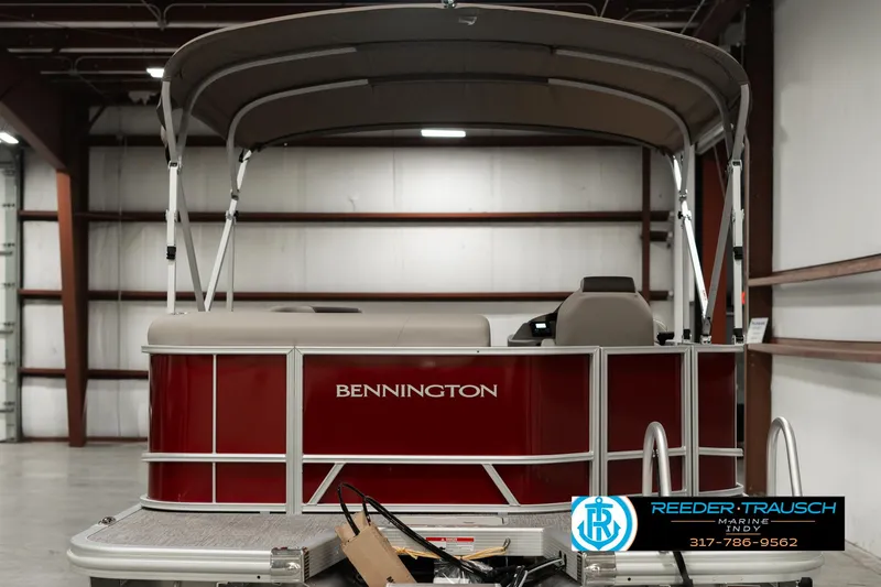 Slide: The Image of 2025 Bennington 21 SLSE pontoon boat in warehouse, red exterior, canopy top. - 6