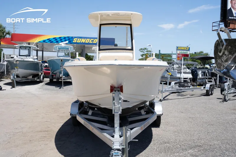 Slide: The Image of 2023 Scout 215 XSF boat on trailer at dealership, sunny day. - 2