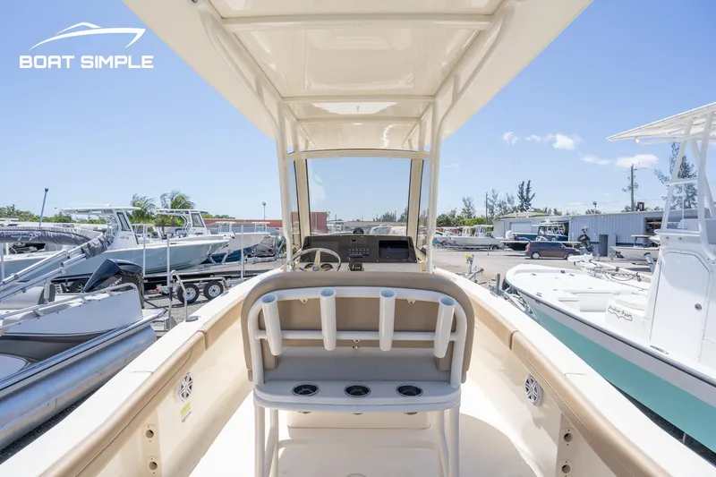 Slide: The Image of 2023 Scout 215 XSF boat interior with console and seating, displayed at a marina. - 8
