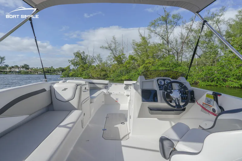 Slide: The Image of 2023 Starcraft SVX 191 OB boat interior with seating and steering console on a sunny day. - 6