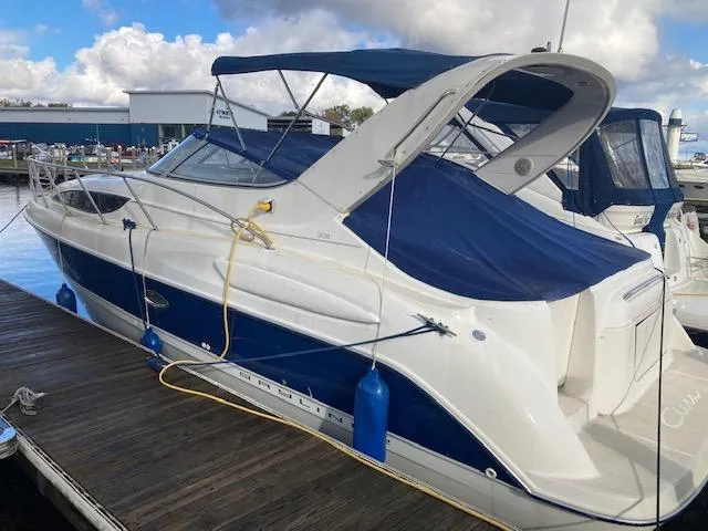 The Image of 2004 Bayliner 3055 Ciera boat docked with blue canopy and fenders. - 1