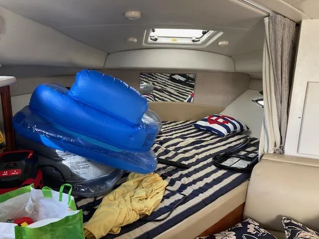 Slide: The Image of Interior of 2004 Bayliner 3055 Ciera with striped bedding and inflatable pool toys. - 11