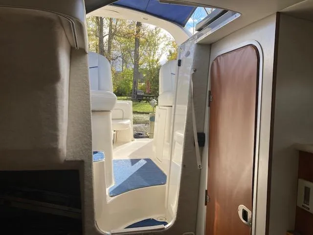 Slide: The Image of Interior view of 2004 Bayliner 3055 Ciera boat, featuring seating and cabin door. - 13