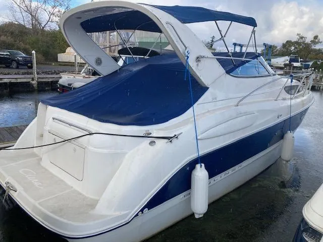 Slide: The Image of 2004 Bayliner 3055 Ciera boat with blue canopy docked at marina. - 3