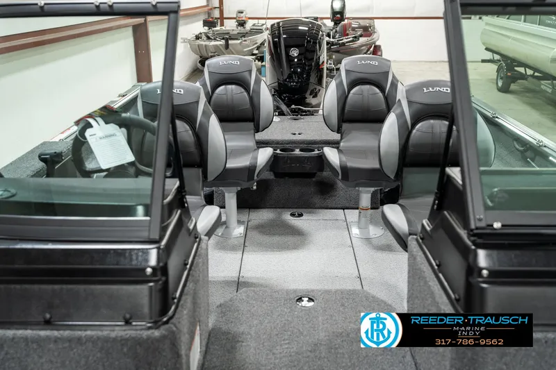 Slide: The Image of 2025 Lund 1775 Impact XS boat interior with seating and windshield, displayed at Reeder-Trausch Marine. - 12