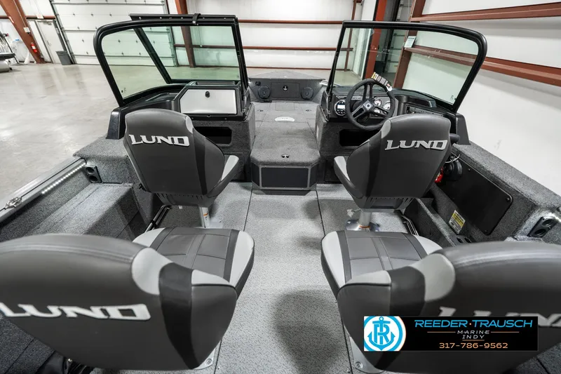Slide: The Image of 2025 Lund 1775 Impact XS boat interior with four seats in a showroom. - 16