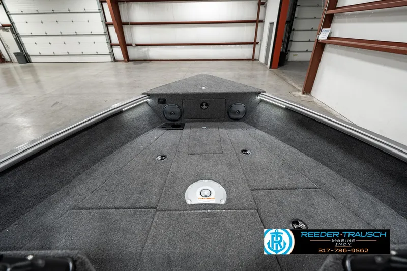 Slide: The Image of 2025 Lund 1775 Impact XS boat interior in a spacious garage setting. - 18