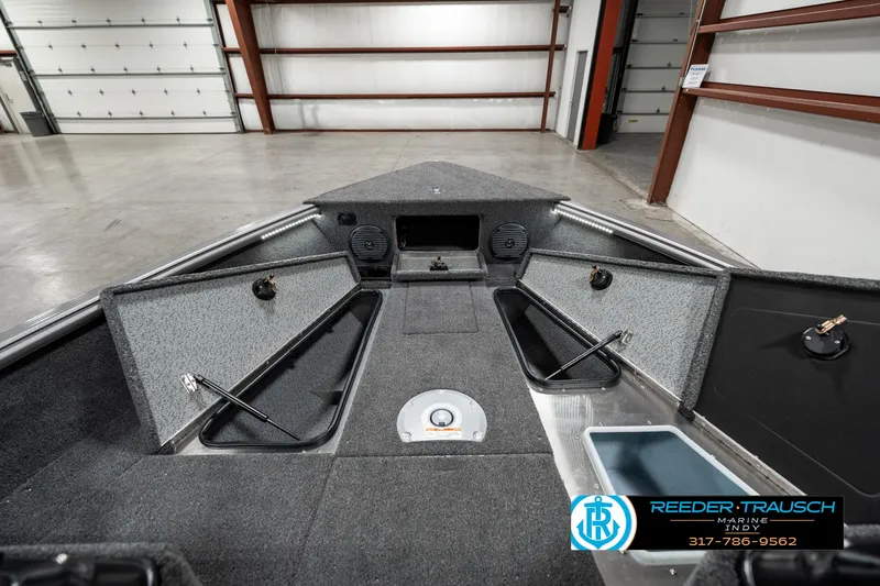Slide: The Image of 2025 Lund 1775 Impact XS boat interior with storage compartments in a garage setting. - 19