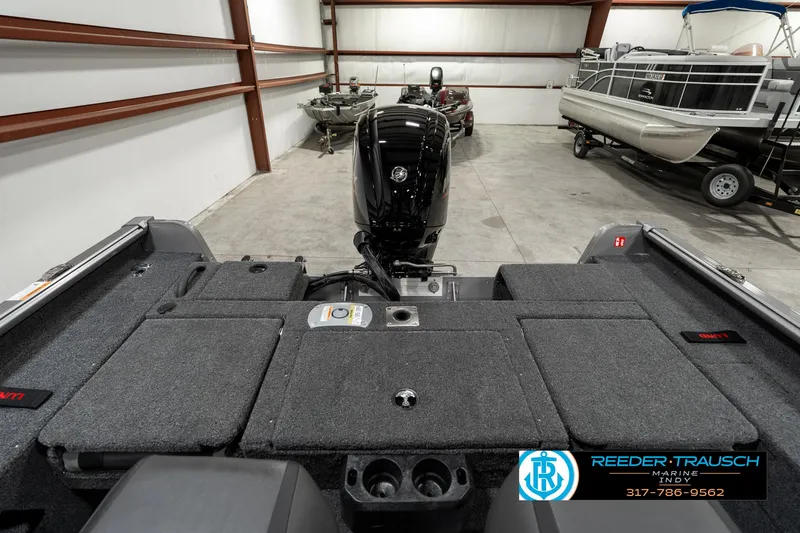 Slide: The Image of 2025 Lund 1775 Impact XS boat interior with motor in a storage facility. - 25