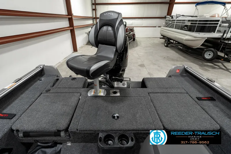 Slide: The Image of 2025 Lund 1775 Impact XS boat interior with seating and storage in a garage. - 26