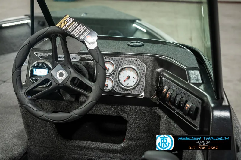 Slide: The Image of 2025 Lund 1775 Impact XS boat dashboard with steering wheel and gauges. - 29