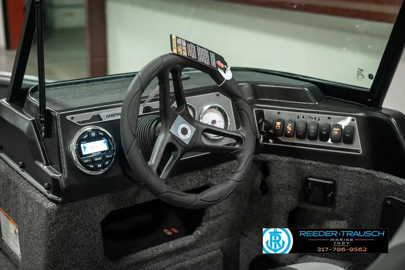 Slide: The Image of 2025 Lund 1775 Impact XS boat dashboard with steering wheel and control panel. - 30