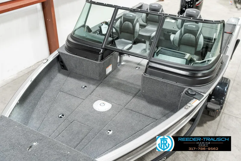 Slide: The Image of 2025 Lund 1775 Impact XS boat interior with seating and windshield, displayed indoors. - 8