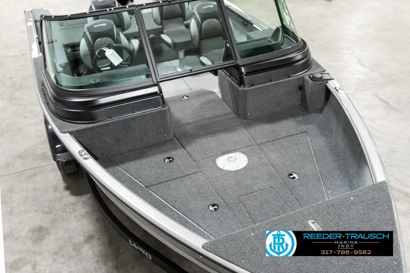 Slide: The Image of 2025 Lund 1775 Impact XS boat with spacious deck and seating, displayed indoors. - 9