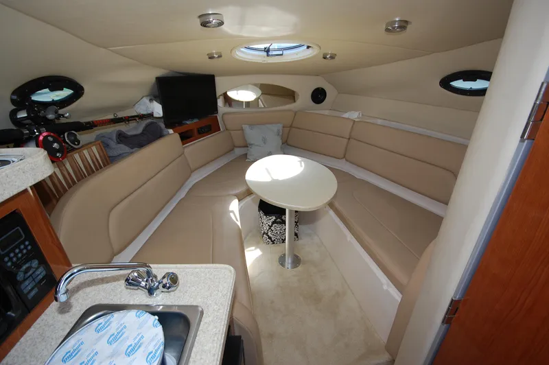 Slide: The Image of 2007 Regal 2665 Commodore cabin interior with seating, table, and kitchenette. - 10