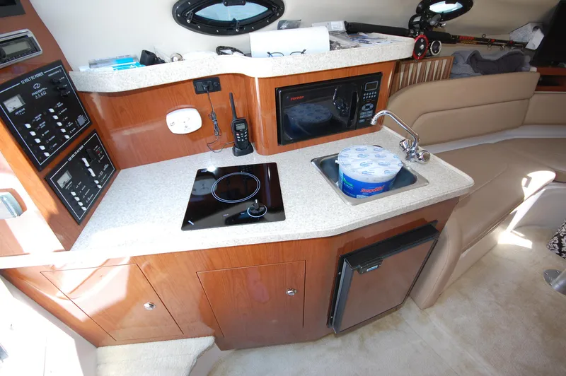 Slide: The Image of 2007 Regal 2665 Commodore boat interior kitchen with stove, sink, and microwave. - 11