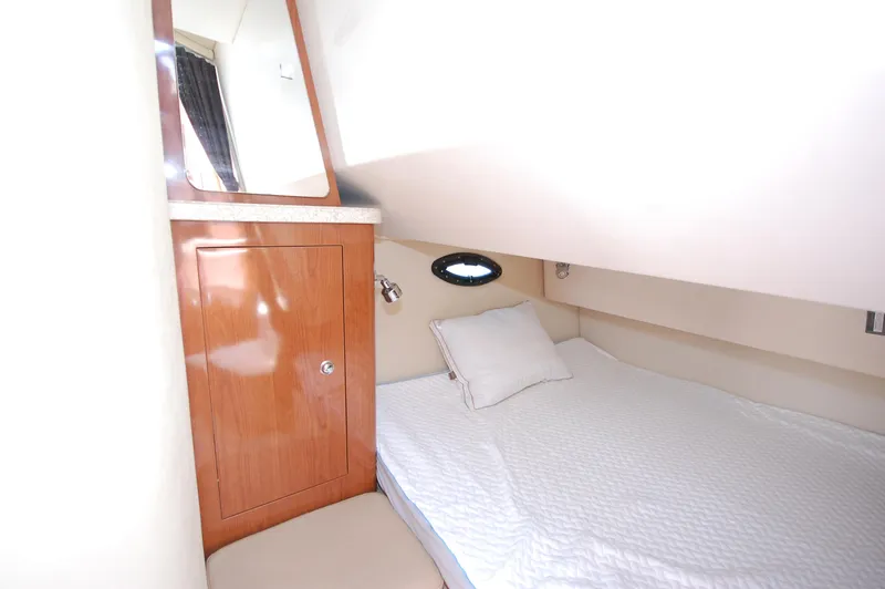Slide: The Image of 2007 Regal 2665 Commodore cabin interior with bed and wooden cabinet. - 13