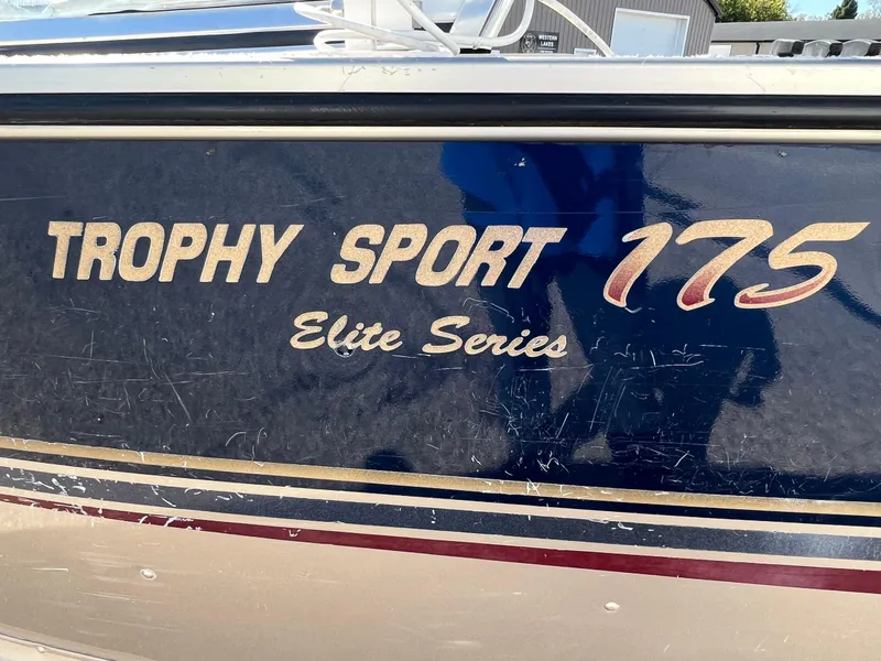Slide: The Image of 2001 Alumacraft Trophy 175 Elite Series boat with blue and gold detailing. - 13