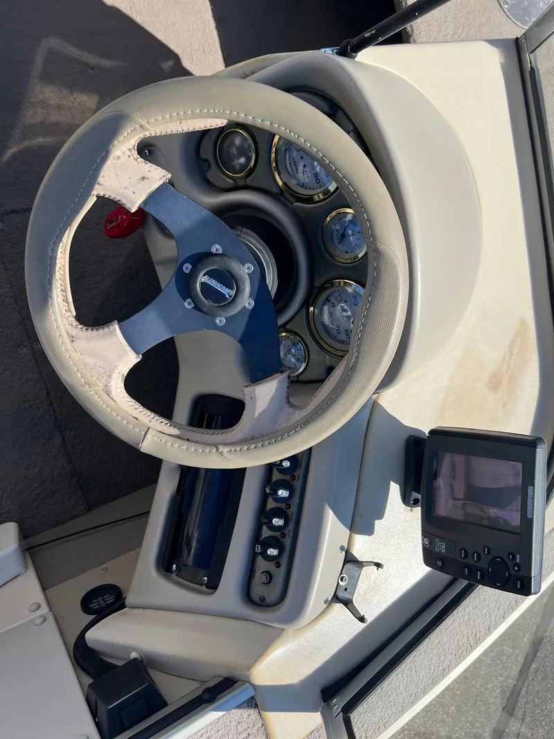 Slide: The Image of 2001 Alumacraft Trophy 175 boat dashboard with steering wheel and gauges. - 16