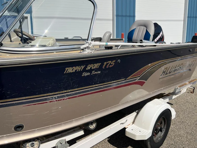 Slide: The Image of 2001 Alumacraft Trophy 175 boat on trailer, side view, outdoors. - 23